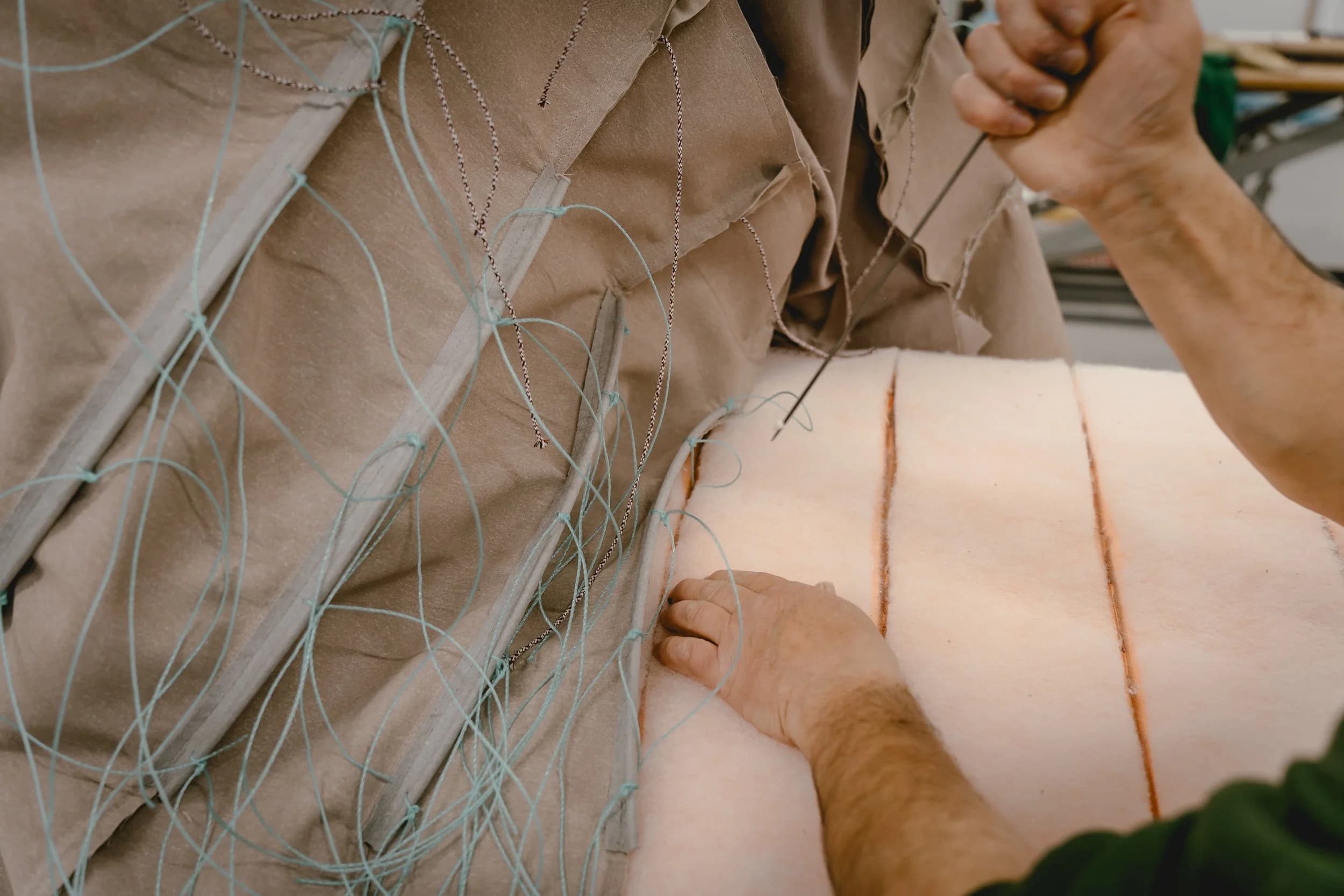 Artisan finishing an upholstered Elbra piece before delivery